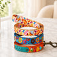 Colorful dog leashes with cartoon designs on a marble surface.