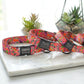 Colorful floral-patterned dog collars with engraved names on a marble surface.