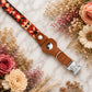 Leather dog collar with geometric pattern on a marble surface with flowers