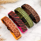 Five patterned dog collars on a marble surface