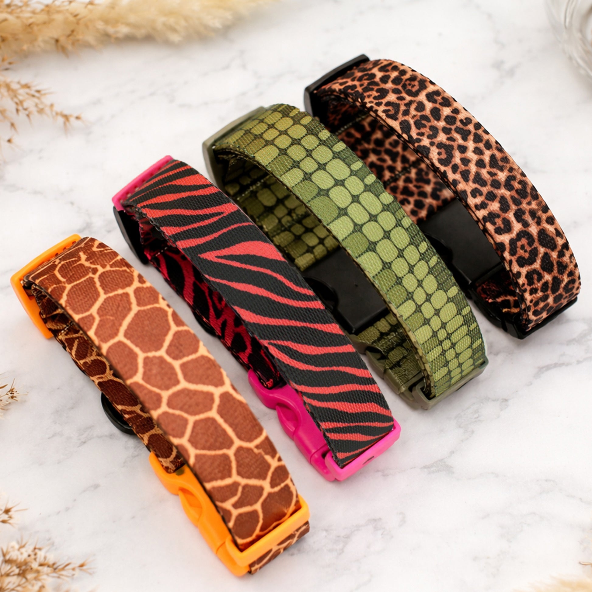 Five patterned dog collars on a marble surface