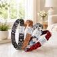 Four dog collars with different patterns and names on a marble surface.
