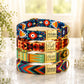 Stack of colorful dog collars with engraved tags on a light surface.
