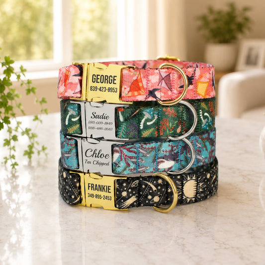 Stack of colorful dog collars with engraved names and contact information on a marble surface.