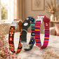 Four dog collars with different patterns on a marble surface with decorative elements.