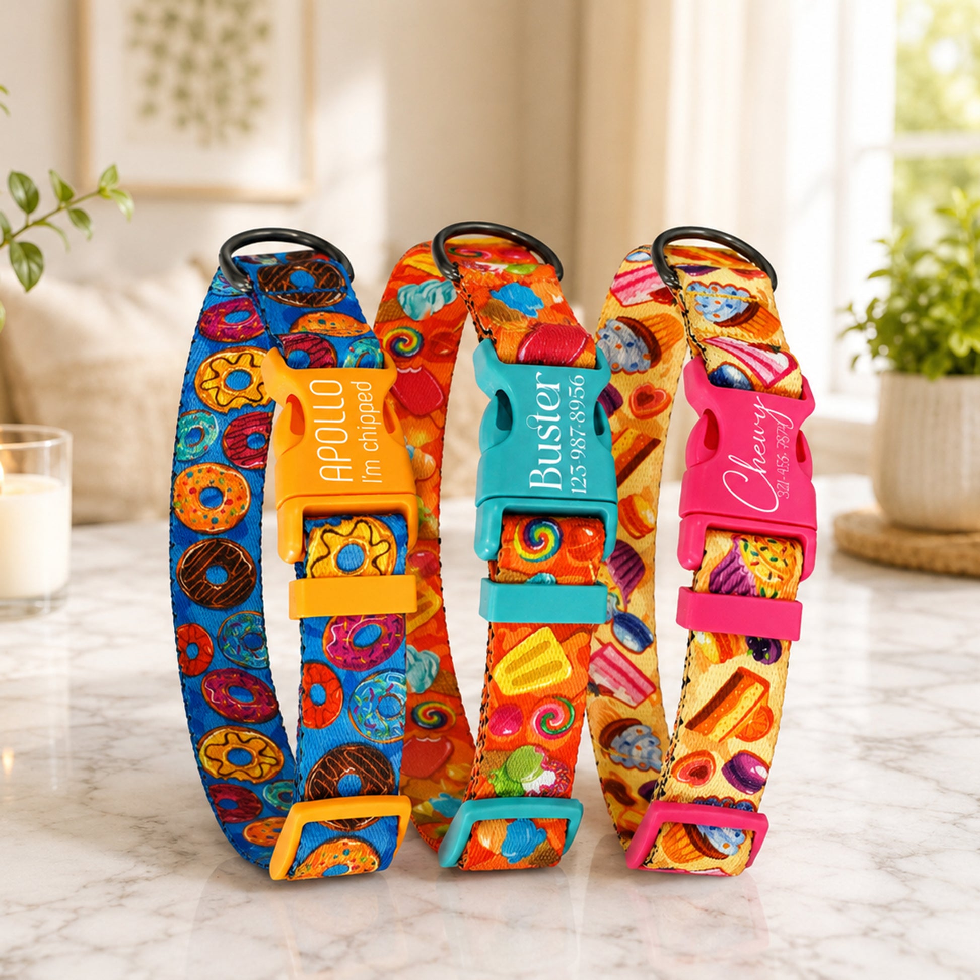 Three colorful dog collars with branded clasps on a marble surface.