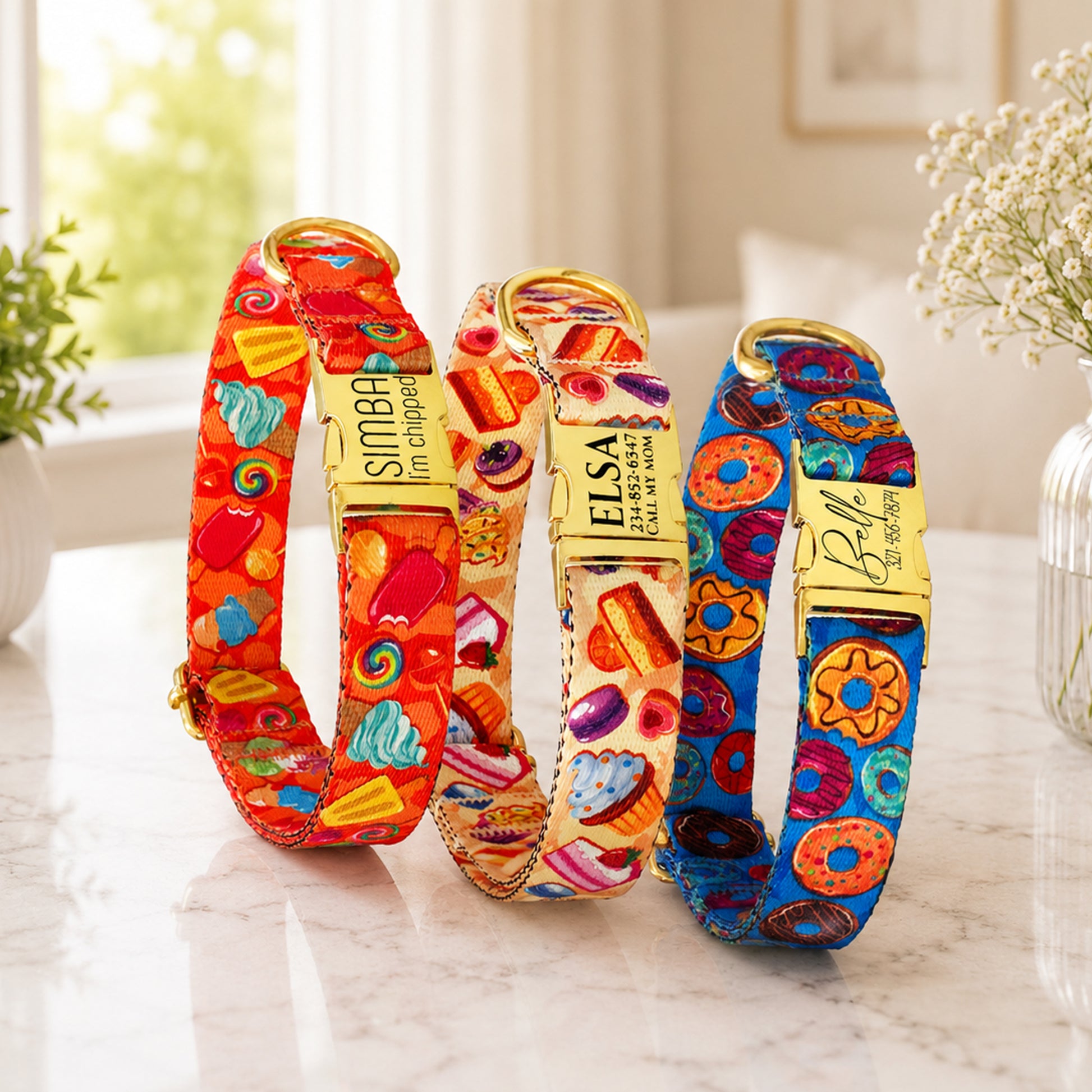 Three colorful dog collars with patterns on a marble surface.