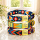 Colorful patterned dog collars with engraved names on a light surface.