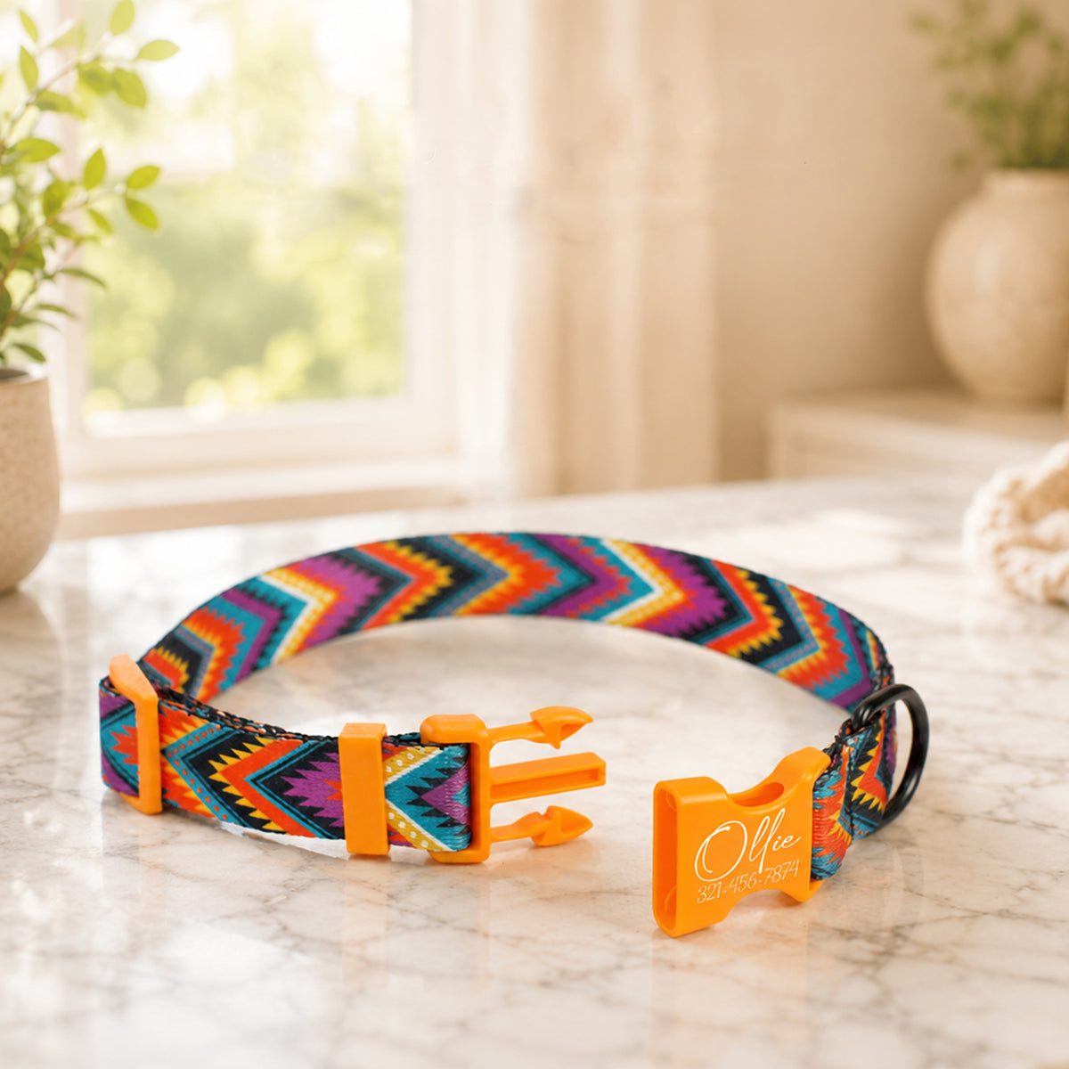 Colorful dog collar with orange clip on a marble surface