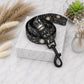 Black and white patterned dog leash on a marble surface with decorative elements.
