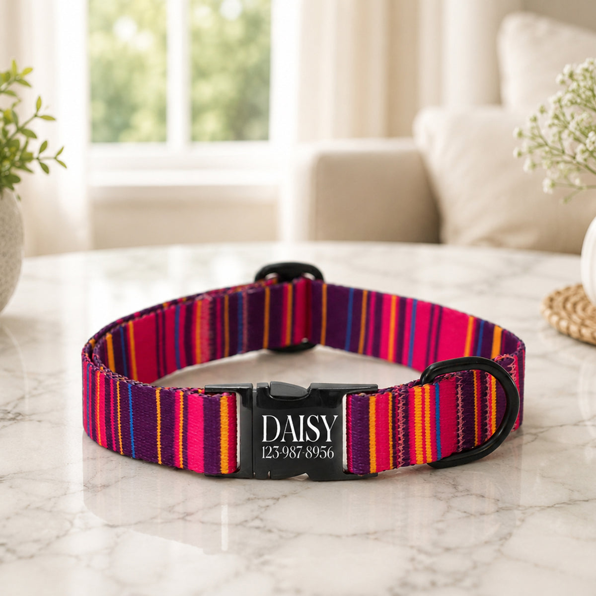 Colorful striped dog collar with a black buckle on a marble surface.