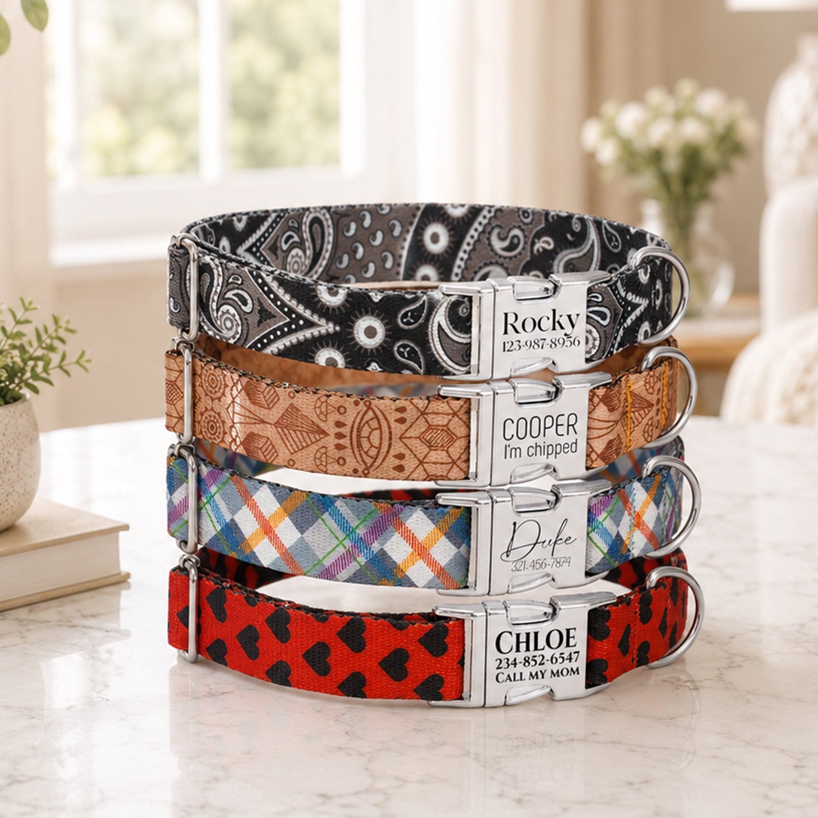 Stack of colorful dog collars with engraved names on a marble surface.