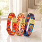 Three colorful dog collars with gold tags on a light surface.
