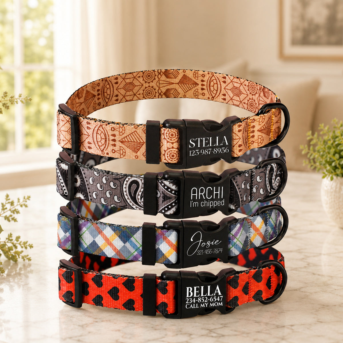 Stack of colorful dog collars with engraved names on a marble surface.