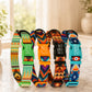 Set of colorful patterned dog collars with engraved names on a light surface.